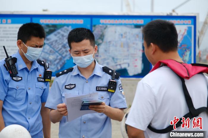 平潭邊檢站移民管理警察對(duì)船員證件進(jìn)行查驗(yàn)?！±钭谒?攝