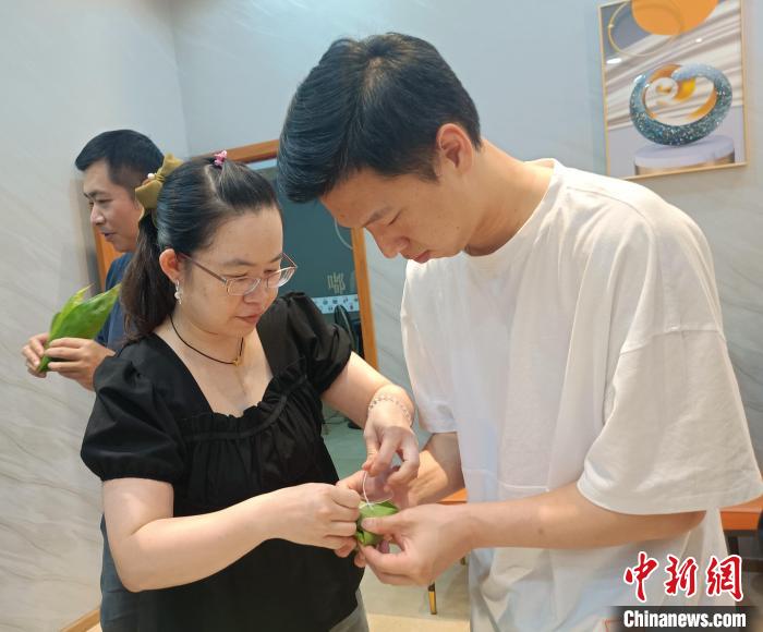圖為臺(tái)青吳攸在學(xué)習(xí)包粽子?！∏褫W軻 攝