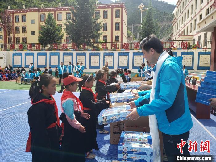 圖為公司員工代表給甘南州迭部縣多兒鄉(xiāng)中心小學(xué)的孩子們分發(fā)文具用品。(資料圖) 馬建斌 攝