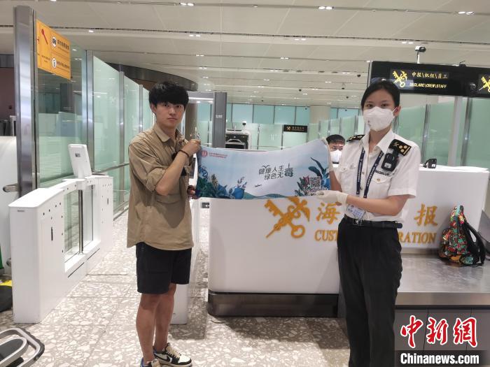圖為大興機場海關(guān)對入境旅客進行禁毒知識宣傳?！±钌袧?攝