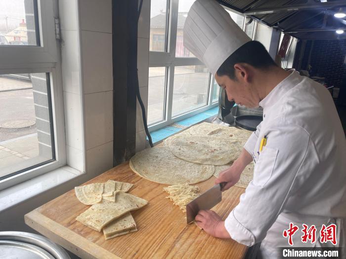 陳經(jīng)偉將餅切成長條備用?！铎o 攝