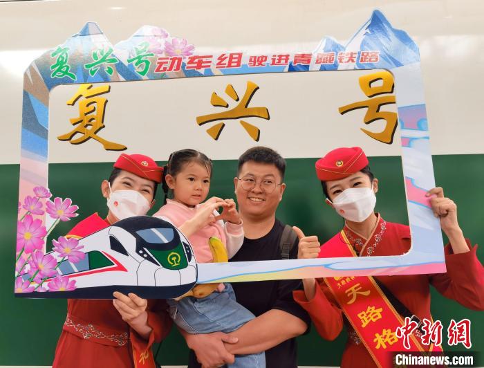 7月1日，旅客在西寧車(chē)站與“復(fù)興號(hào)”紀(jì)念牌合影留念。中新社記者 祁增蓓 攝