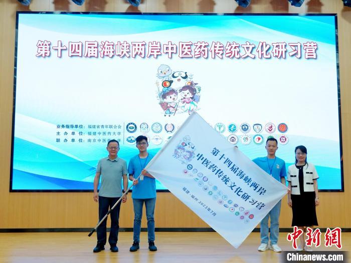 共青團(tuán)福建省委副書記吳雪(右一)、福建中醫(yī)藥大學(xué)黨委副書記林羽(左一)為兩岸學(xué)生代表頒授營旗。　許燁婷 攝