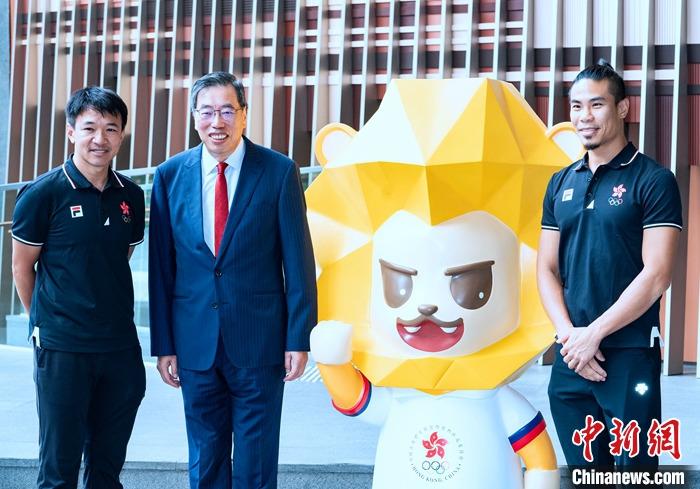 7月5日，香港立法會(huì)主席梁君彥在立法會(huì)綜合大樓出席為即將出征杭州2022年第19屆亞運(yùn)會(huì)的中國(guó)香港代表團(tuán)加油打氣活動(dòng)。圖為梁君彥(左二)與香港前自行車運(yùn)動(dòng)員黃金寶(左一)、前空手道運(yùn)動(dòng)員李嘉維(右一)在本屆中國(guó)香港代表團(tuán)吉祥物獅子“堅(jiān)仔”旁合影。 <a target='_blank' href='/'>中新社</a>記者 侯宇 攝