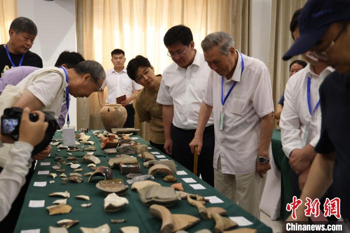 與會(huì)專家查看永濟(jì)渠故道、武城遺址出土陶、瓷碎片等?！↓R紅雨 攝