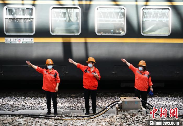 7月6日，在南昌車站，為到達的列車加滿清水后，上水工胡飛英和工友們比劃手勢準備通過軌道上站臺?！『鷩?攝