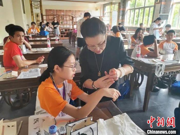 珊麗娜指導(dǎo)華裔少年做盤扣?！∩虾Ｊ袃S聯(lián)供圖