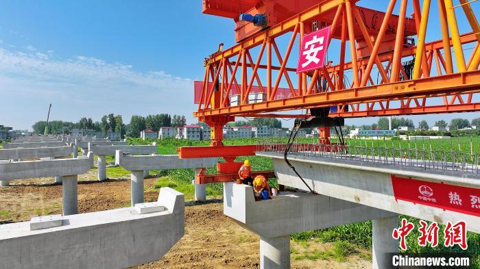 長25米重80噸的箱梁平穩(wěn)、精準地落在S314分離式立交橋25號和26號墩上?！⒂癫?攝