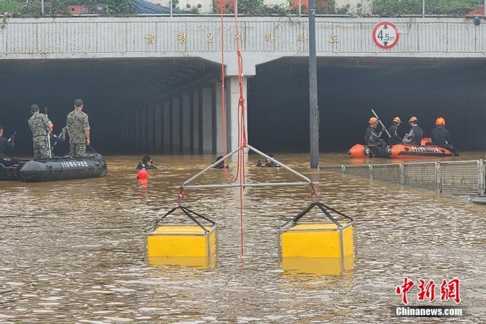 韓國(guó)救援人員沿著一條被洪水淹沒(méi)的道路搜尋失蹤人員，這條道路通往被洪水淹沒(méi)的地下隧道。視覺(jué)中國(guó)