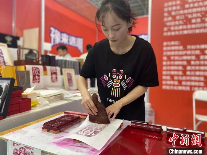 7月14日，周口華威民俗文化博物苑的講解員杜奧杰在文博會(huì)現(xiàn)場(chǎng)展示拓印。中新社記者張瑋攝