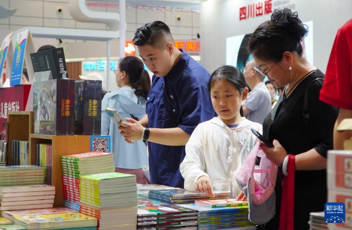 7月27日，在第31屆全國圖書交易博覽會上，讀者在閱覽新書。新華社記者 徐速繪 攝