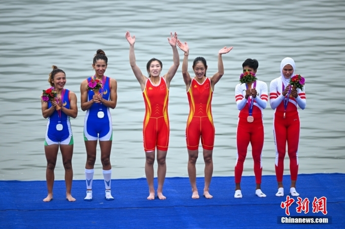 9月24日，杭州第19屆亞運會賽艇女子輕量級雙人雙槳決賽在浙江杭州舉行，中國組合鄒佳琪、邱秀萍以7分06秒78的成績奪冠。這是本屆亞運會的首枚金牌。圖為頒獎儀式上，鄒佳琪(左三)、邱秀萍(右三)揮手致意。<a target='_blank' href='/'>中新社</a>記者 王剛 攝