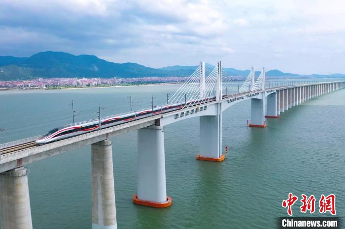 9月28日，復(fù)興號(hào)智能動(dòng)車組行駛在福廈高鐵湄洲灣跨海大橋。歷經(jīng)6年多時(shí)間建設(shè)，全長(zhǎng)277公里的福廈高鐵，穿越多處山脈，跨越多處海灣，將難上九重天的閩道與大海緊緊相連。李響攝