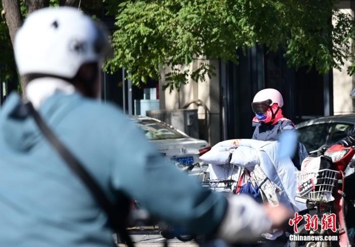 石家莊街頭，市民紛紛穿上厚厚的外套“捂”裝前行。 <a target='_blank' href='/'>中新社</a>記者 翟羽佳 攝