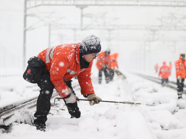 工作人員對(duì)鐵路道岔采取除雪等措施。