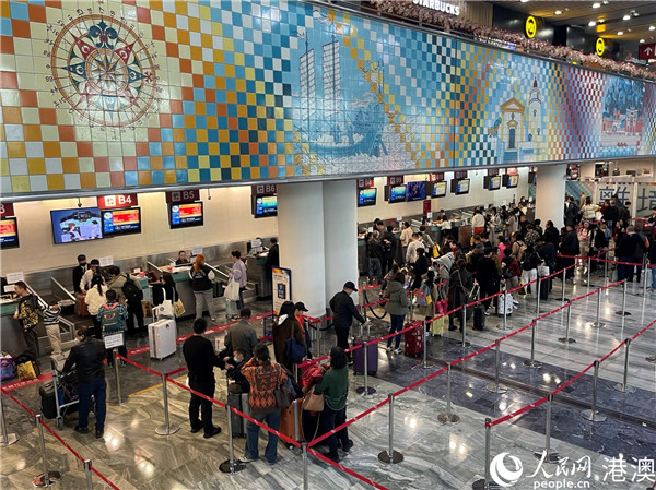 圖為離境旅客有序排隊(duì)辦理登機(jī)牌。人民網(wǎng)記者 富子梅攝
