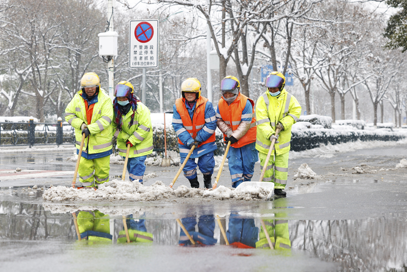 2月4日，在江蘇省宿遷市泗洪縣泗州大街，工作人員在清掃路面積雪。（圖源：新華社）