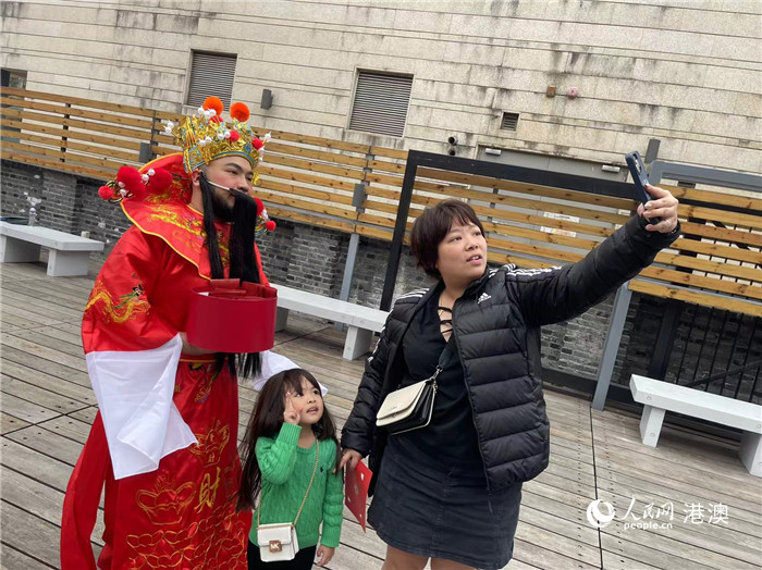 圖為送出吉祥如意的財(cái)神與游客合影。人民網(wǎng)記者 富子梅攝