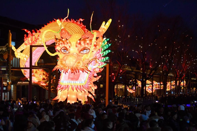 2月14日，在北京市西城區(qū)什剎海荷花市場(chǎng)，游客觀賞巨型龍燈“蛟龍出海”。新華社記者 鞠煥宗 攝