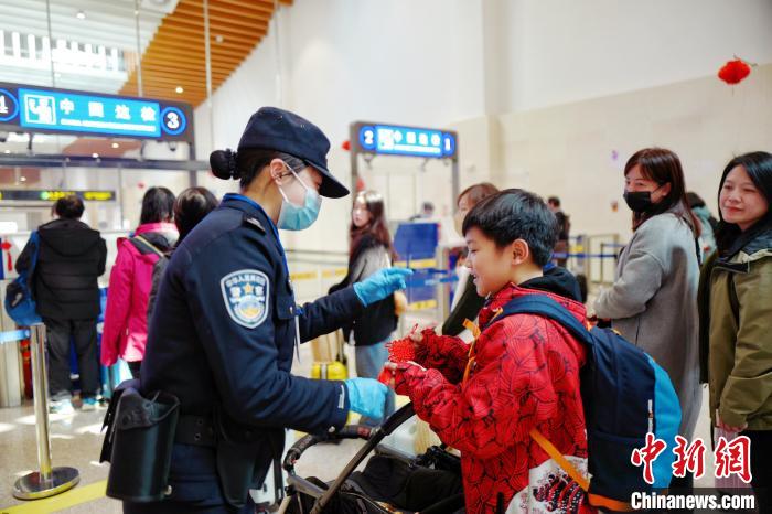 2月10日，福州出入境邊防檢查站移民管理警察向入境臺(tái)胞贈(zèng)送中國(guó)結(jié)。　楊馨 攝