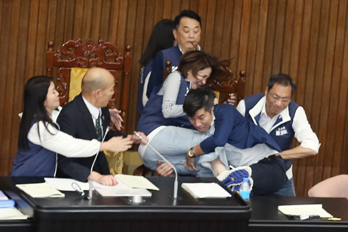 民進黨立法委員鐘佳濱（右二）趁著表決的空擋沖上主席臺，國民黨陳菁徽（右三）擋在主席臺前被鐘佳濱撲倒