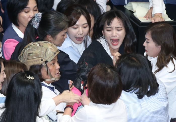 民進黨立委黃捷（中右）等人想趁國民黨放松防備之際突襲，與國民黨立委陳玉珍（中左）發(fā)生拉扯沖突