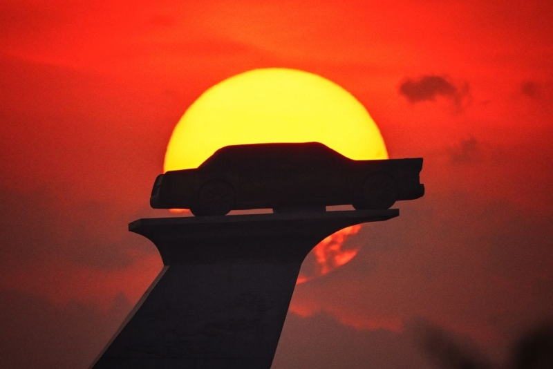 2023年6月17日，長(zhǎng)春市汽車廣場(chǎng)內(nèi)的汽車雕塑沐浴在晨曦中。（圖源：新華社）