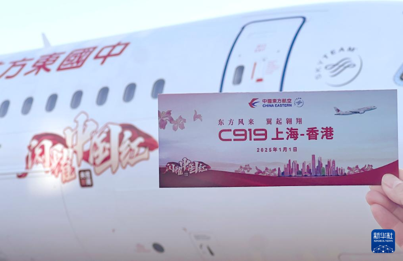 1月1日，東航工作人員在C919執(zhí)飛的MU721航班前展示紀念機票。新華社發(fā)（東方航空供圖）
